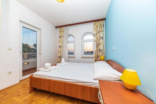 una camera con un grande letto e due finestre di Sea View Apartments Sirena Okrug Gornji a Okrug Gornji
