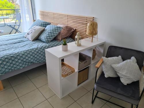 a bedroom with a bed with a night stand and a chair at Chez Malo in Perros-Guirec