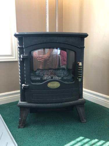 a black fireplace in a room with green carpet at Knights Inn Huntsville in Huntsville