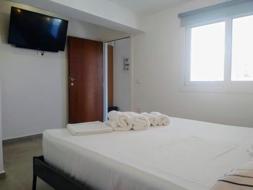 a bedroom with a white bed with towels on it at Estella Studios in Elafonisos