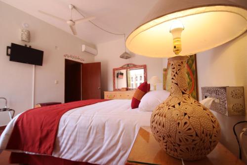 a bedroom with a large bed with a lamp on it at Hotel Hacienda Don Cenobio in San Pablo Villa de Mitla