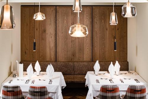 two tables in a restaurant with white tablecloths at Sporthotel Obereggen in Obereggen