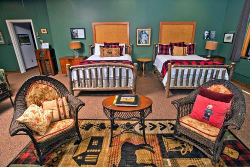 a room with two beds and two chairs and a table at Sherman Inn in Ogdensburg