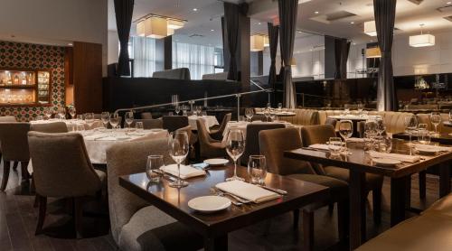 a restaurant with tables and chairs with wine glasses at Century Plaza Hotel in Vancouver