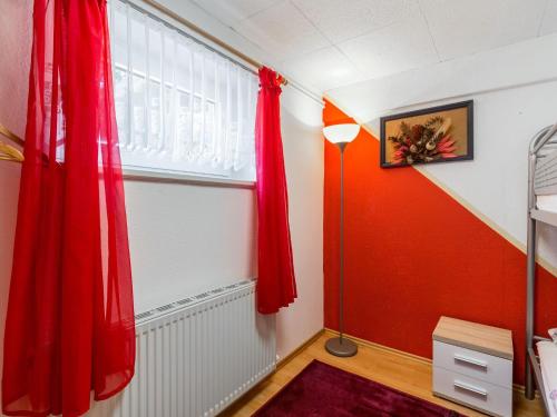 a bedroom with a red curtain and a window at Pleasant Apartment in Damshagen with Terrace and Barbecue in Damshagen