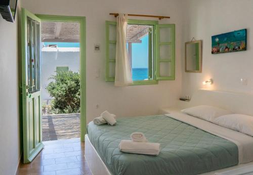 a bedroom with a bed with a view of the ocean at Sunset Studios & Rooms in Antiparos