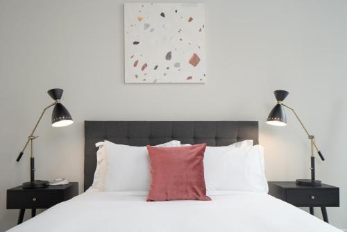a bedroom with a white bed with two lamps at Kasa River North Chicago in Chicago