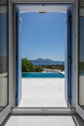 an open window with a view of a swimming pool at Blu Suites and Studios in Adamas