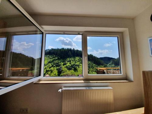 a window with a view of a green hill at Haus Goldfuß in Pottenstein