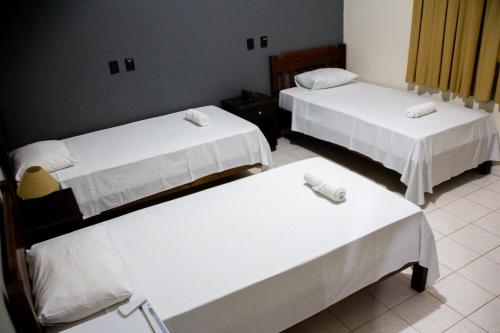 a room with two beds and two tables at Polo Hotel Fazenda in Indaiatuba