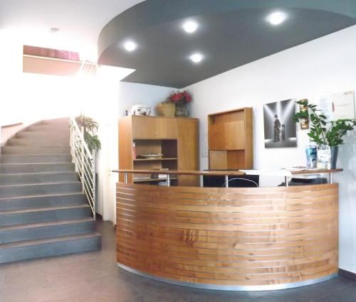 a lobby with a staircase and a wooden counter at Hotel Ariston in Bolzano