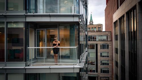 a woman standing on a balcony of a building at reStays Ottawa in Ottawa