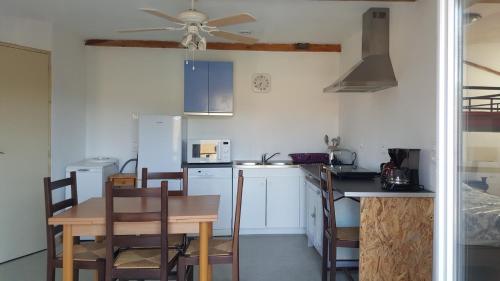 a kitchen with a table and a ceiling fan at Périgord Curiosités in Coux-et-Bigaroque