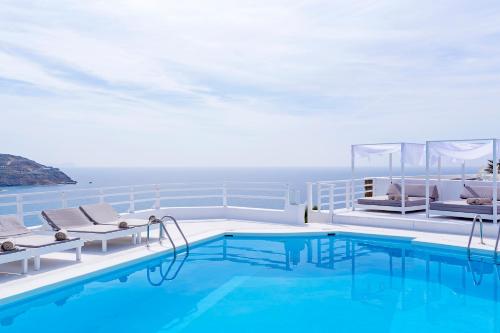 a pool on a cruise ship with chairs and a swimming pool at Pietra e Mare - Mykonos Moments in Kalo Livadi