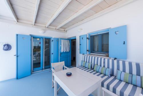 a room with blue walls and a white table and chairs at Blu Suites and Studios in Adamas