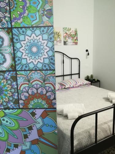 two pictures of a bedroom with a bed and a mural at CASA Zia Sarina in Noto