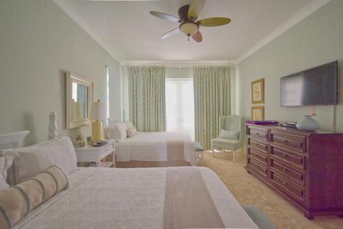 Habitación de hotel con 1 dormitorio con 1 cama y TV en Cozy 4BDR villa in luxury beach resort with service staff and view of La Cana golf course, en Punta Cana