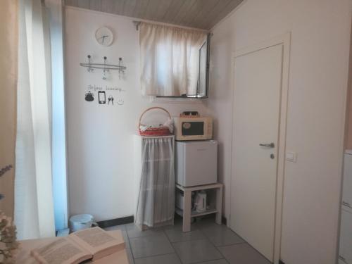 een kleine kamer met een magnetron bovenop een koelkast bij Camera romantica nel carugio in Riomaggiore