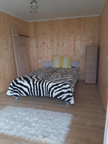 a zebra print bed in a room with a rug at CAZARE LA ESPAÑOLA in Haţeg