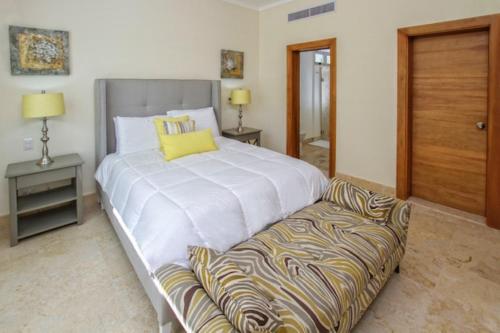 a bedroom with a large bed and a couch at Spacious 3 BDR fully-equipped condo with pool and golf view in Punta Cana