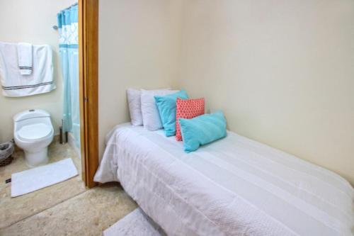 sypialnia z łóżkiem z poduszkami w obiekcie Spacious 3 BDR fully-equipped condo with pool and golf view w Punta Cana