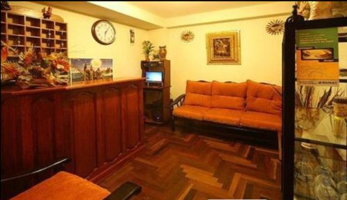 sala de estar con sofá y reloj en la pared en Suyay B&B, en Cusco