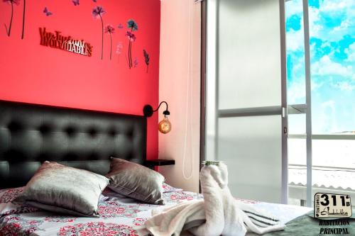 a bedroom with a bed with a red wall at Apartamento Cerca Al Parque Del Cafe con piscina in Montenegro