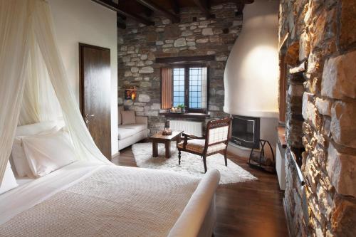 - une chambre avec un lit et un mur en pierre dans l'établissement Adis Oneirou, à Mouresi