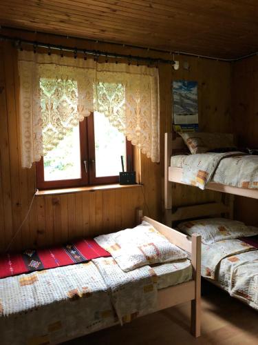 two bunk beds in a room with a window at Planinska kuca Mitke in Prolesje