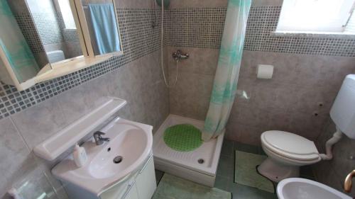 a bathroom with a sink and a toilet and a shower at Apartment Klimno 3 in Klimno