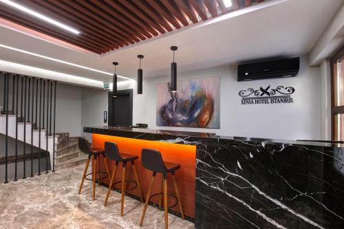 a lobby with a black and orange bar with stools at Xenia Hotel Istanbul in Istanbul