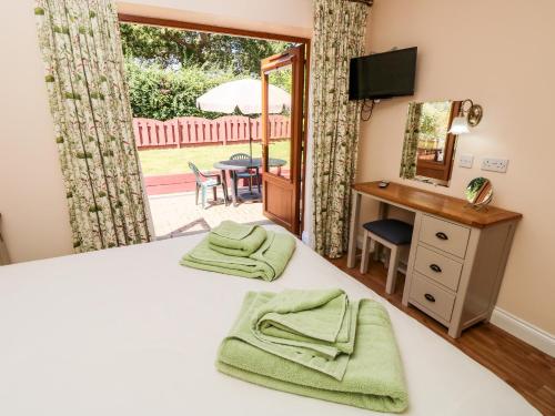 a bedroom with a bed and a desk and a window at 1 The Stables in Haven Street