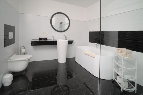a bathroom with a sink and a toilet and a mirror at Designapartments Level 2 - Sennhütte 5 in Wernigerode