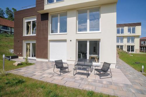 un gruppo di sedie seduti su un patio di fronte a una casa di Designapartments Die besondere ART - Sennhütte 7 a Wernigerode