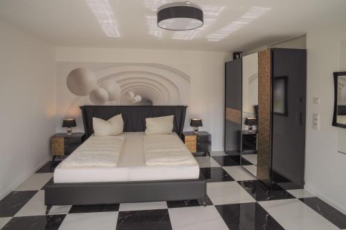 a bedroom with a bed with a black and white checkered floor at Designapartments Die besondere ART - Sennhütte 7 in Wernigerode