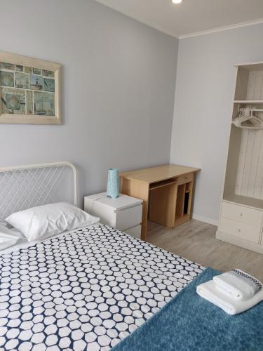 a bedroom with a bed and a desk and a desk at Long Beach Apartamento AL in Praia da Vitória