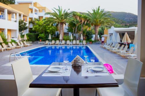 a dining table and chairs next to a swimming pool at Xidas Garden in Balíon