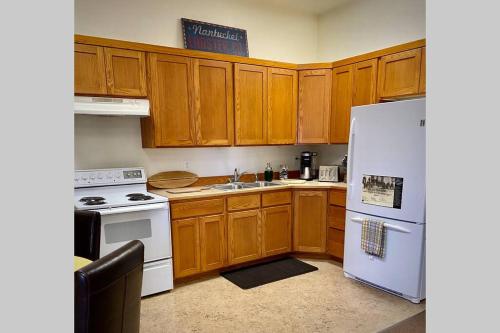een keuken met houten kasten en een witte koelkast bij Park Place - The Boardwalk 112-B in Darby