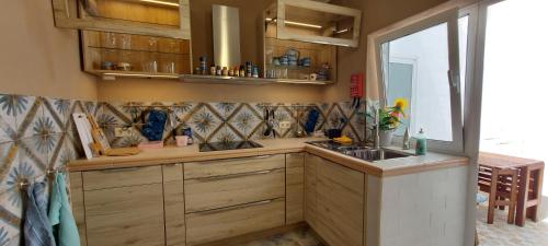a kitchen with wooden cabinets and a sink and a window at Studio Pescador in Olhão