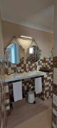 a bathroom with a counter with a mirror and a sink at Studio Pescador in Olhão