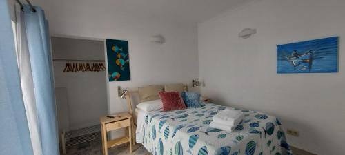 a small bedroom with a bed and a picture on the wall at Studio Pescador in Olhão