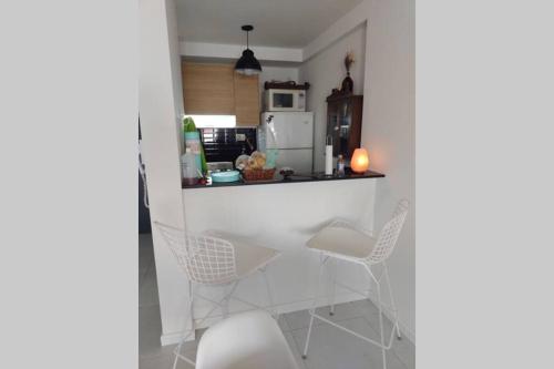 a kitchen with white chairs and a white table at departamento céntrico relax in Rosario