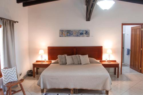 1 dormitorio con 1 cama con 2 mesas y 2 lámparas en La Capilla Hotel en Dolores Hidalgo