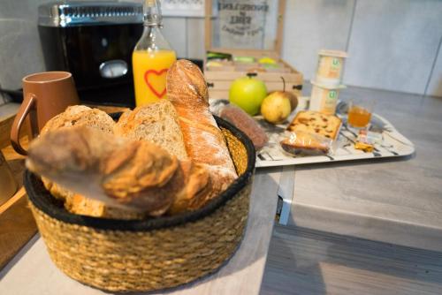 een mand brood op een aanrecht met een bord eten bij LOVE Suites & SPA "Le Loft" avec Jacuzzi privatif in Médis