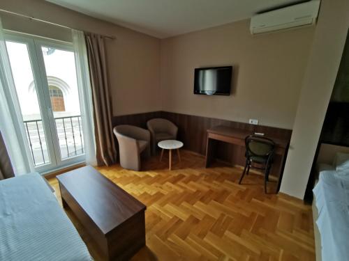 a hotel room with a desk and a tv at Villa Salvia in Mostar