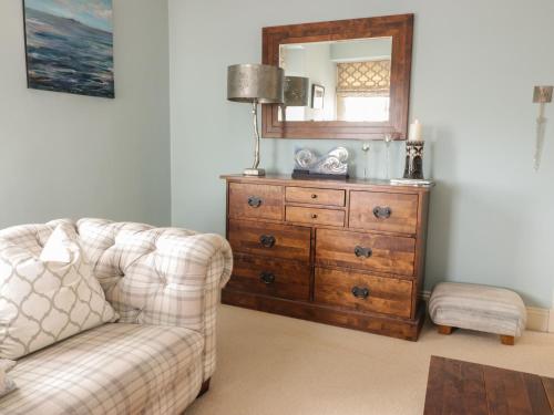a living room with a couch and a dresser with a mirror at Invermay in Anstruther