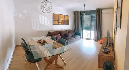 ein Wohnzimmer mit einem Glastisch und einem Sofa in der Unterkunft Beach House Carmen in Monte Gordo