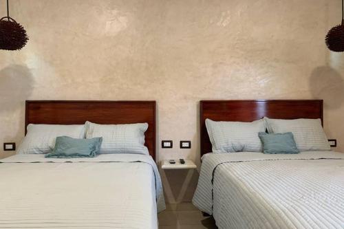 two beds sitting next to each other in a bedroom at Baona Bacalar in Bacalar
