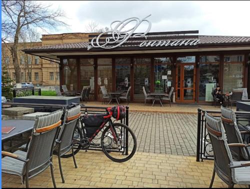 a bike parked in front of a table and chairs at LOFT-Style Apartment in Izmail
