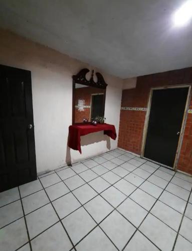 a room with a red table and a mirror at Habitación completa a 2 Cuadras del Consulado EUA in Nuevo Laredo